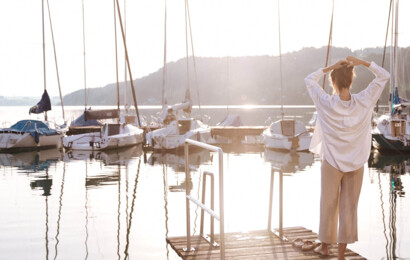 Frau am See auf Steg und Booten
