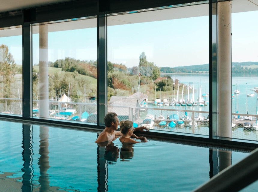 Ein Paar genießt den Ausblick vom Balkon auf den See