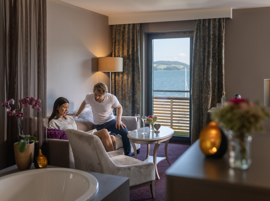 Ein Paar macht es sich auf dem Sofa im Hotelzimmer gemütlich