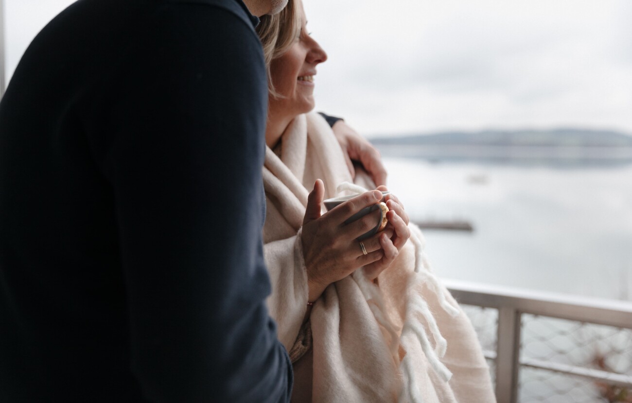 Ein Paar genießt den Ausblick vom Balkon auf den See