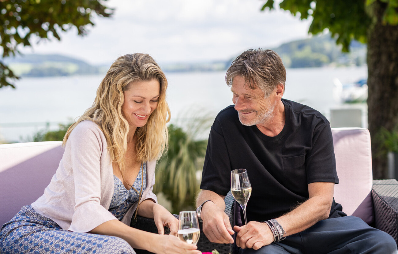 Ein Paar genießt ein Glas Sekt in der Lounge am Mattsee