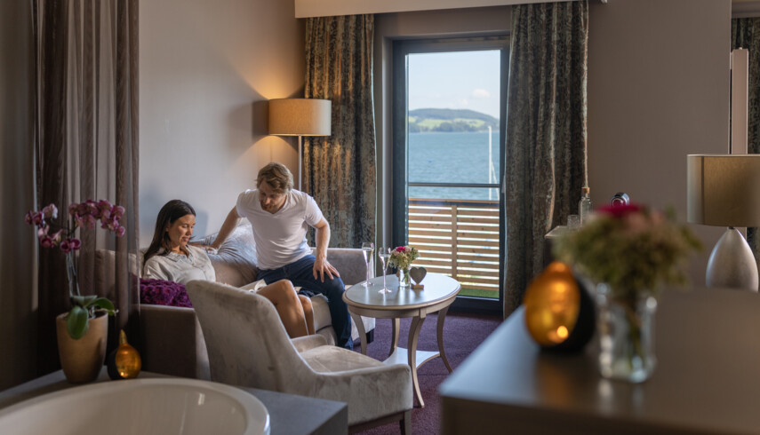 Ein Paar macht es sich auf dem Sofa im Hotelzimmer gemütlich