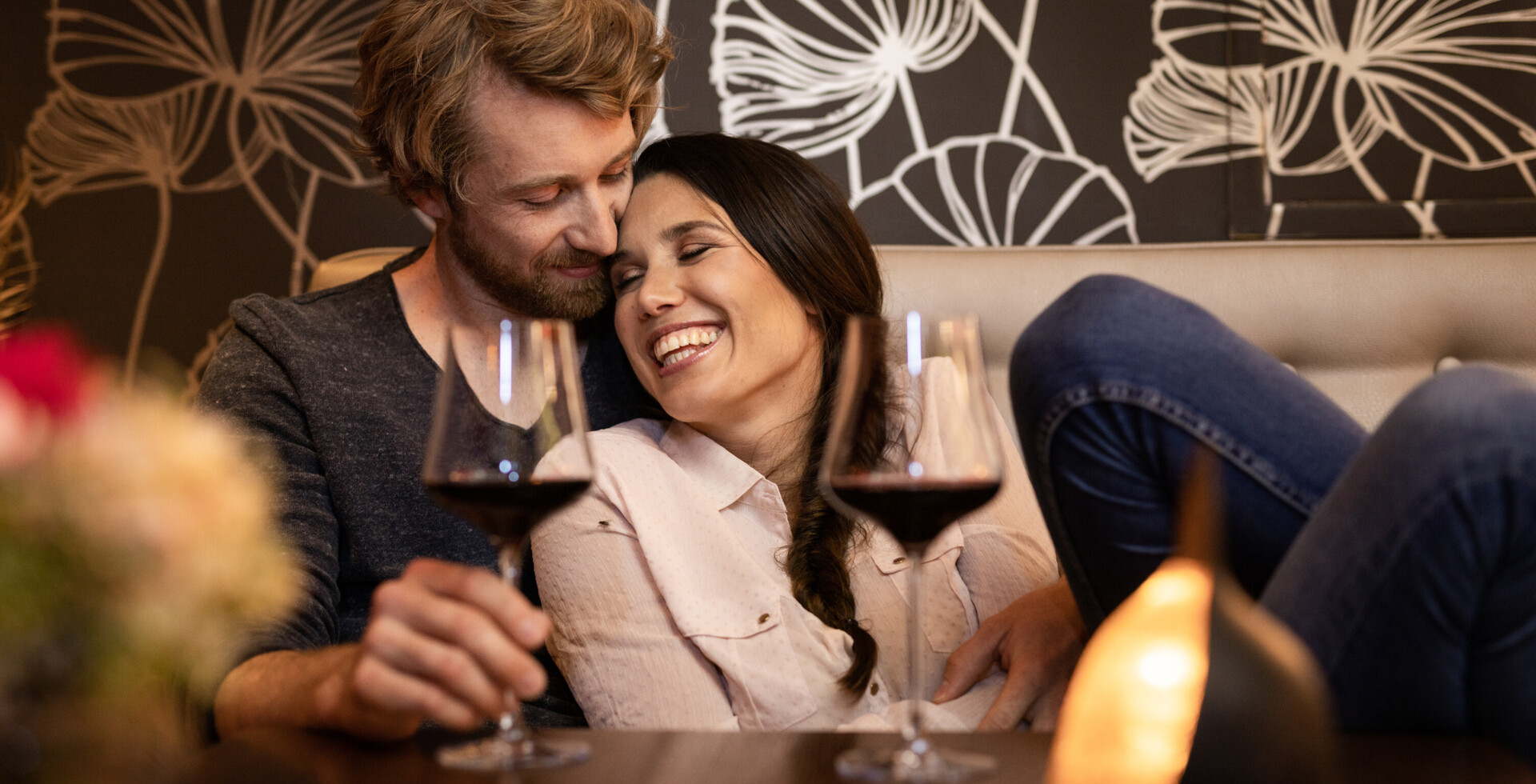 Ein Paar genießt im romantischen Hotel in Österreich ein Glas Rotwein