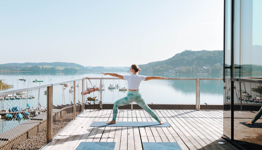 Frau macht Yoga am See