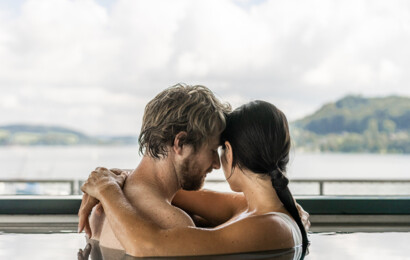 Ein Paar im Infinity-Pool mit Seeblick