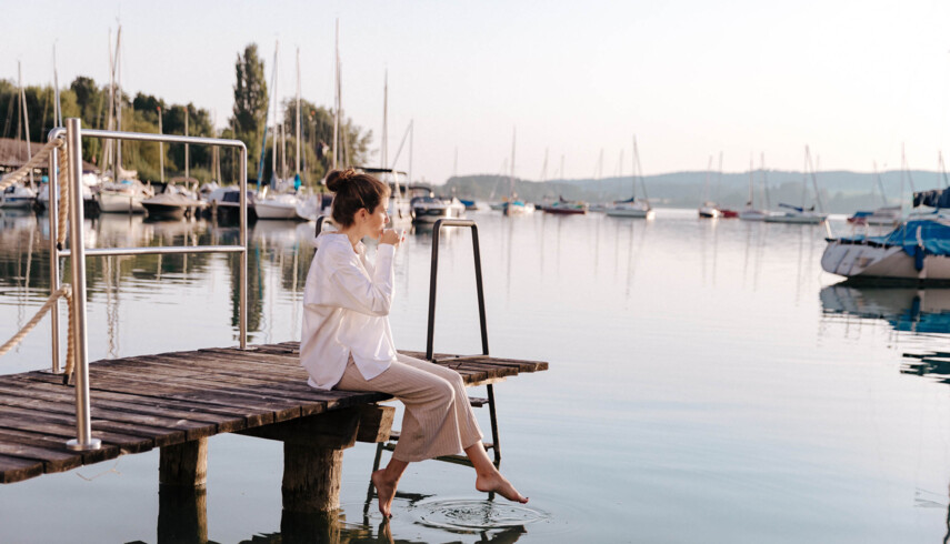 Frau am See mit Segelbooten