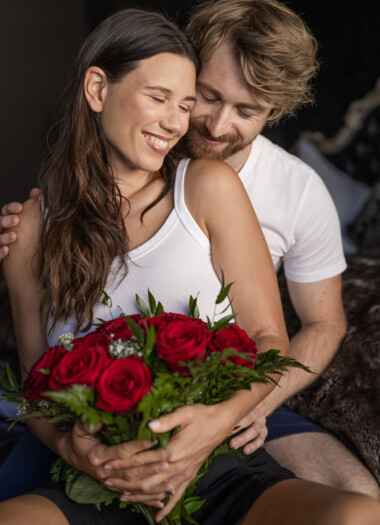 Ein Paar sitzt eingewickelt in Decken mit einem Glas Wein auf der Terrasse