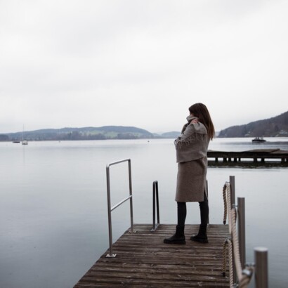 Frau am See auf Steg und Booten