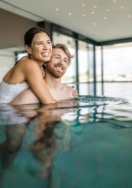 Ein Paar umarmt sich im Infinity-Pool