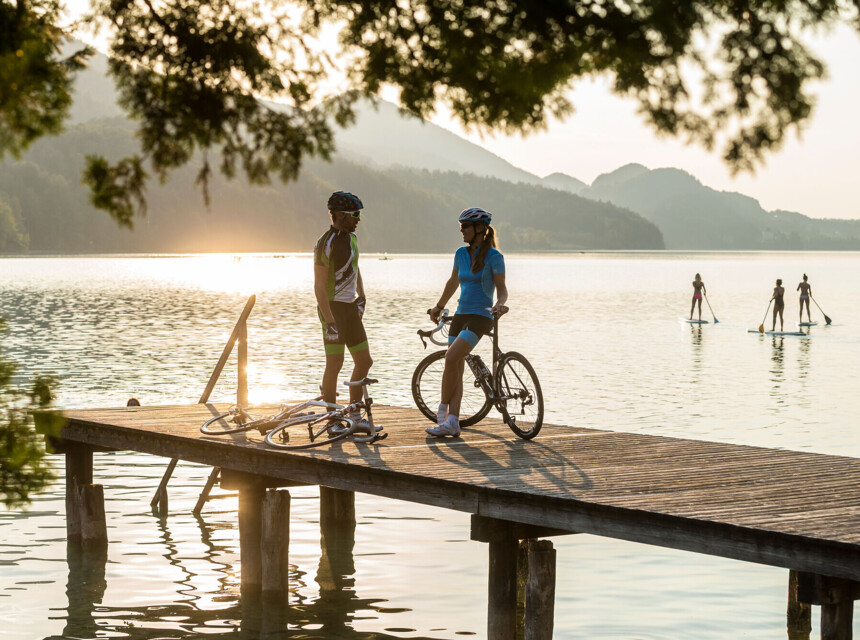 Frau und Mann mit Fahrrad stehen am Ufer des Sees